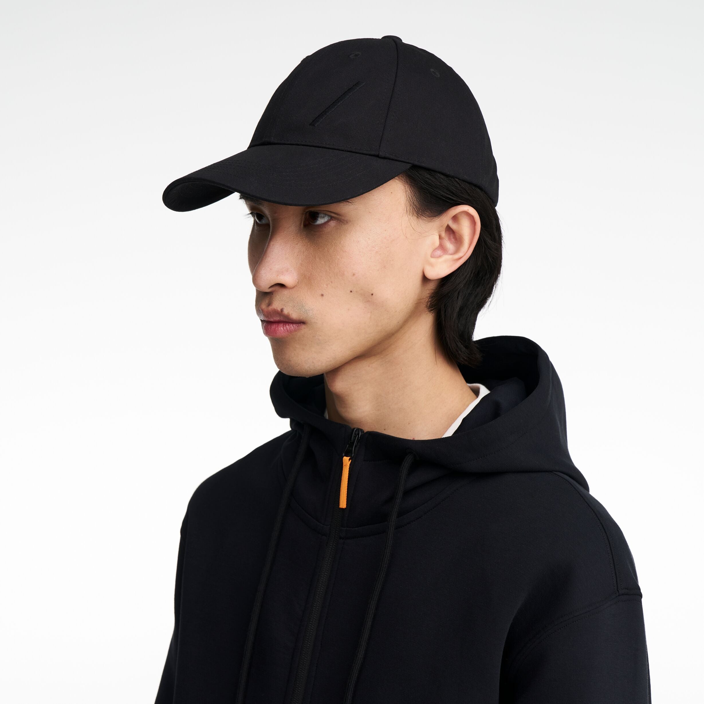 The Volvo Classic Cap in black, worn by a male model. It features an embroidered diagonal logo on the side. 
