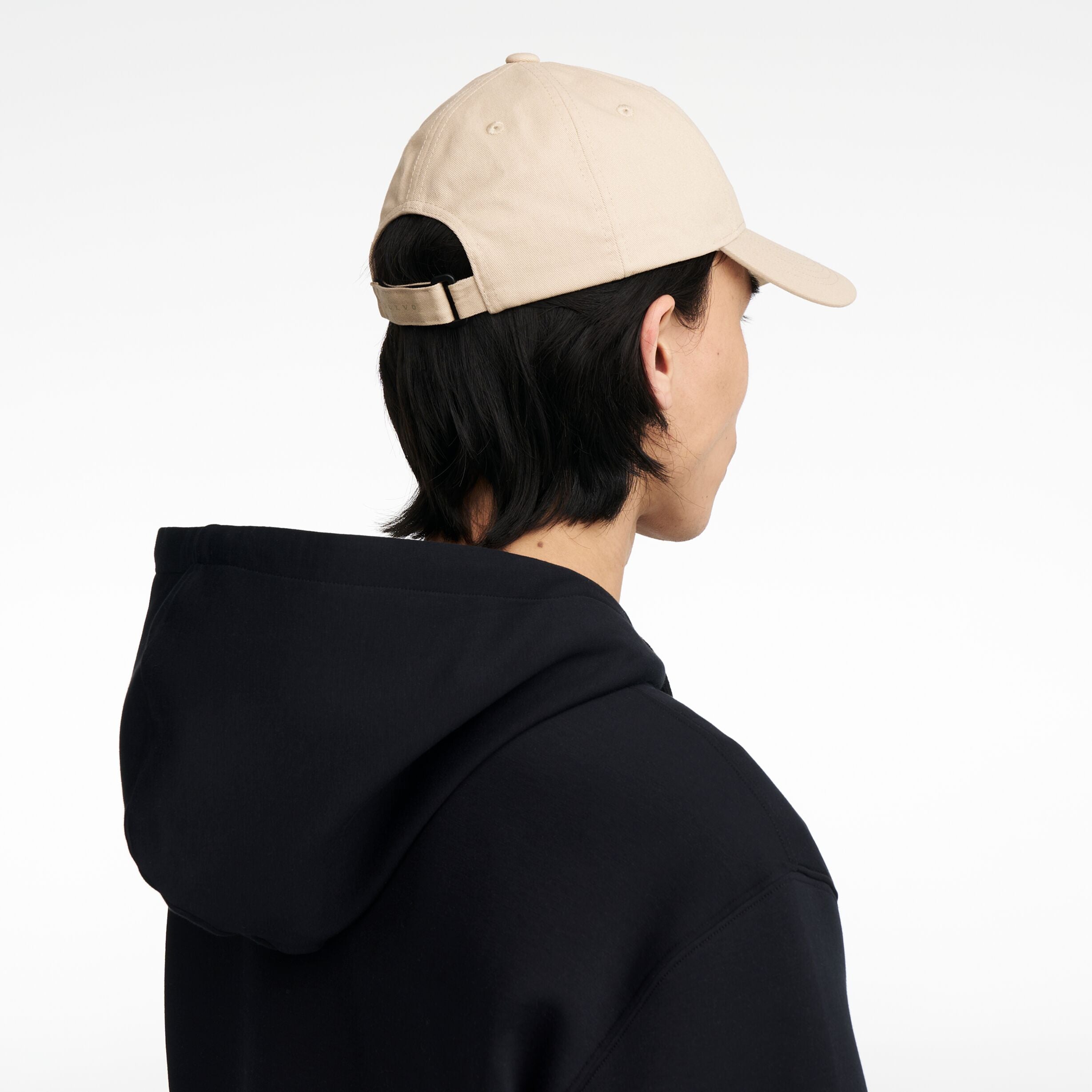 The Volvo Classic Cap in dune, worn by a male model. It features an embroidered diagonal logo on the side. 
