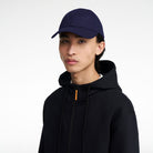 The Volvo Classic Cap in navy, worn by a male model. It features an embroidered diagonal logo on the side. 