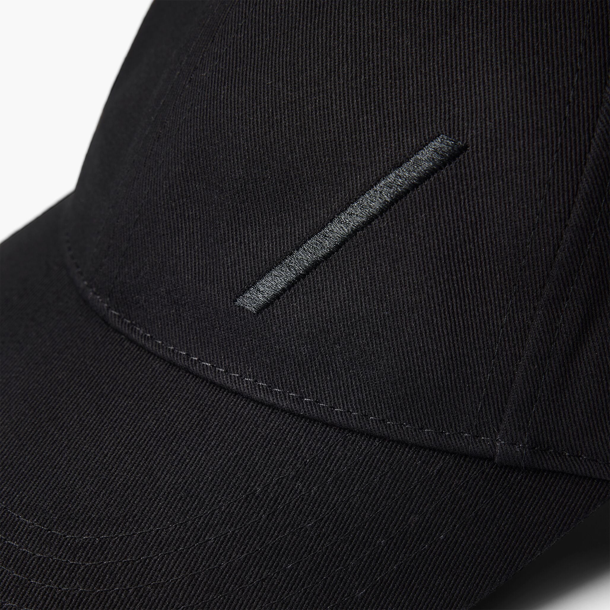 Volvo Classic Cap in black, featuring an embroidered diagonal logo. Cut-out image with a plain background. 