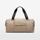 The taupe coloured Volvo Duffle Bag against a white background, with shoulder and cross-body straps, water-repellent exterior and Volvo Diagonal logo.
