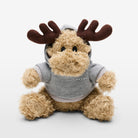 The Volvo Elk Soft Toy against a white background. We see the furry toy sitting, with brown antlers, a cuddly furry body and a grey hoodie with white Volvo logo.