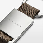 A close-up view of the Volvo Key Chain in grey.  We see the solid metal with Volvo logo at the centre, with strap and key ring at the top.