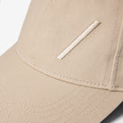 Volvo Classic Cap in dune, featuring an embroidered diagonal logo. Cut-out image with a plain background. 