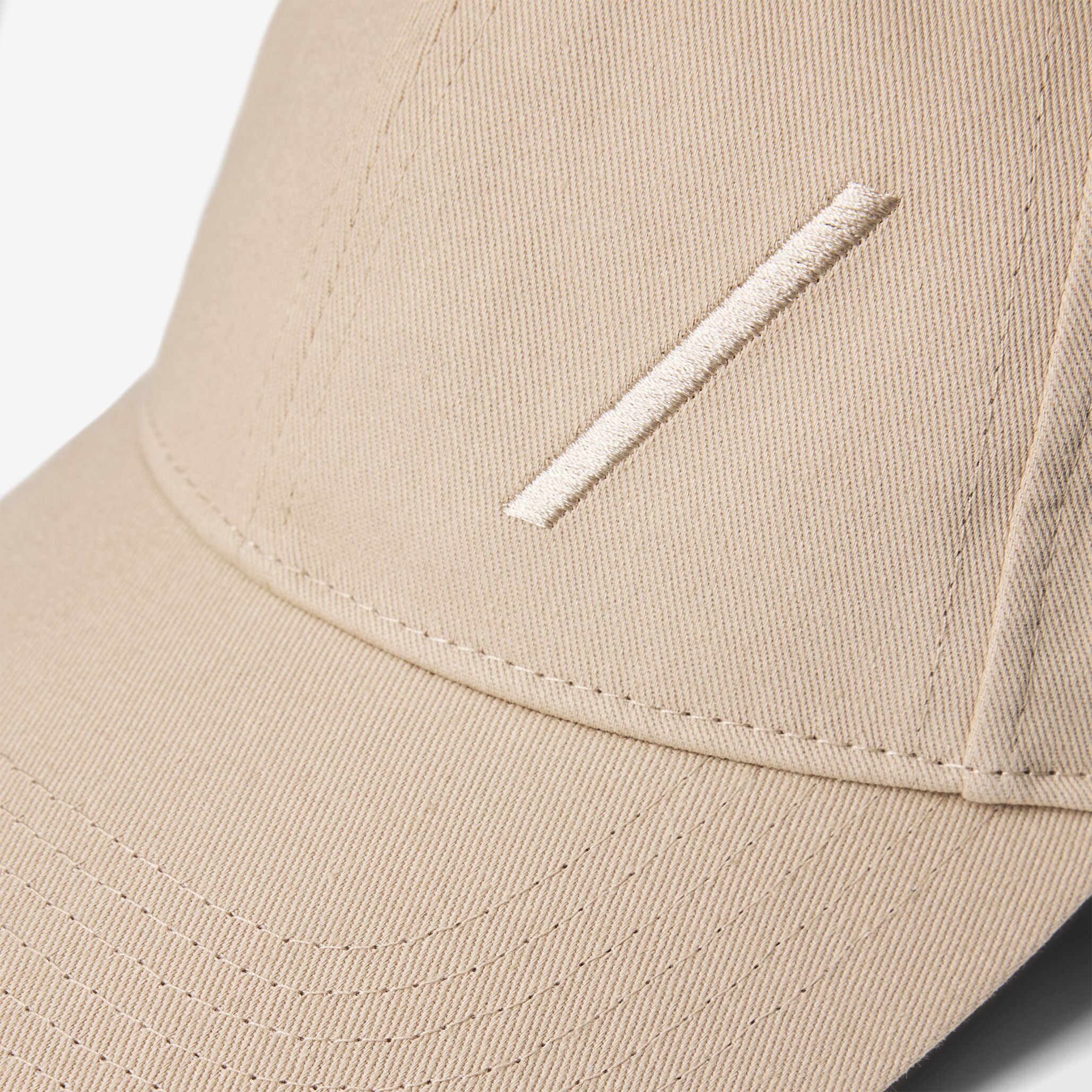 Volvo Classic Cap in dune, featuring an embroidered diagonal logo. Cut-out image with a plain background. 