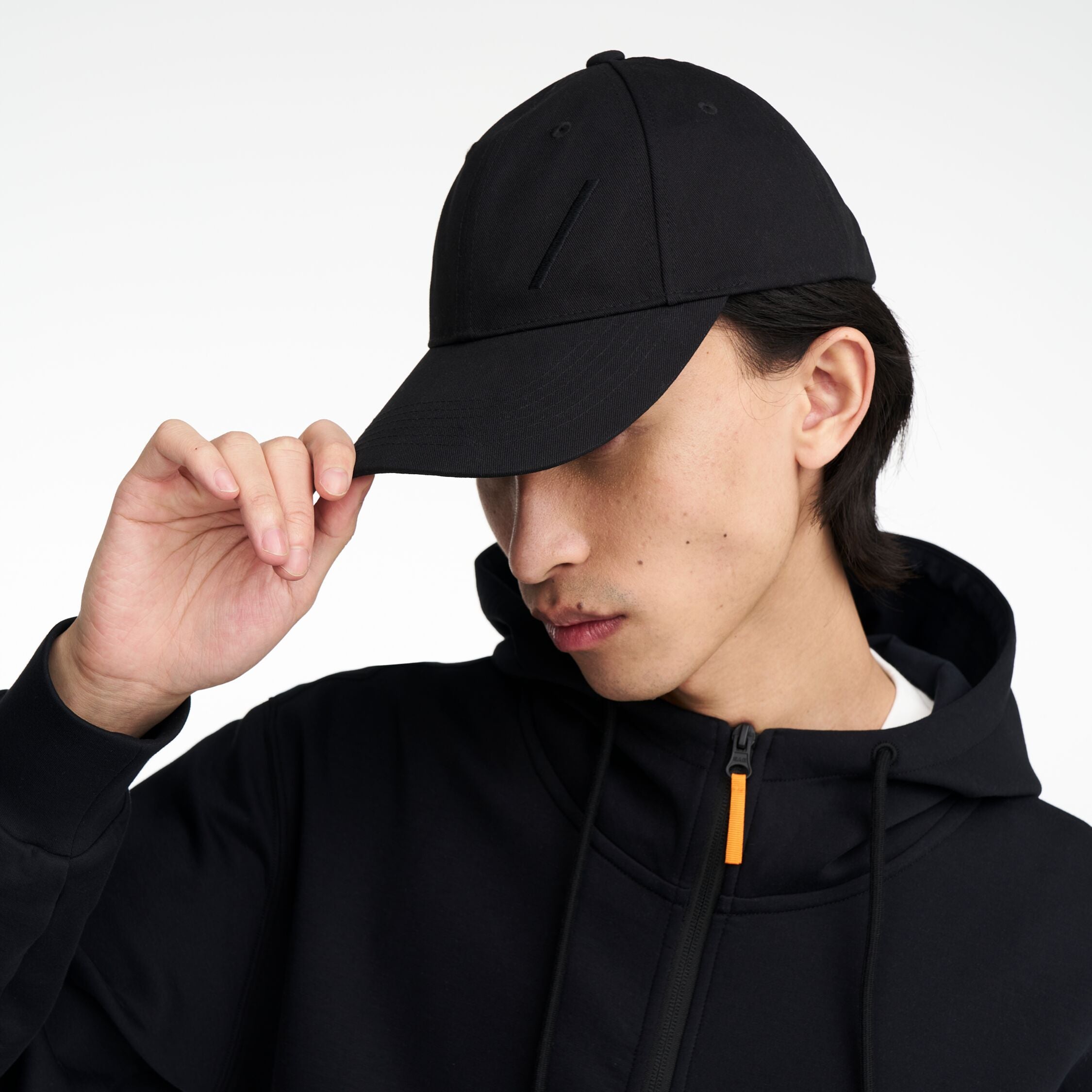 The Volvo Classic Cap in black, worn by a male model. It features an embroidered diagonal logo on the side. 