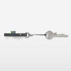 Keychain with a key and a flag attached on a white background
