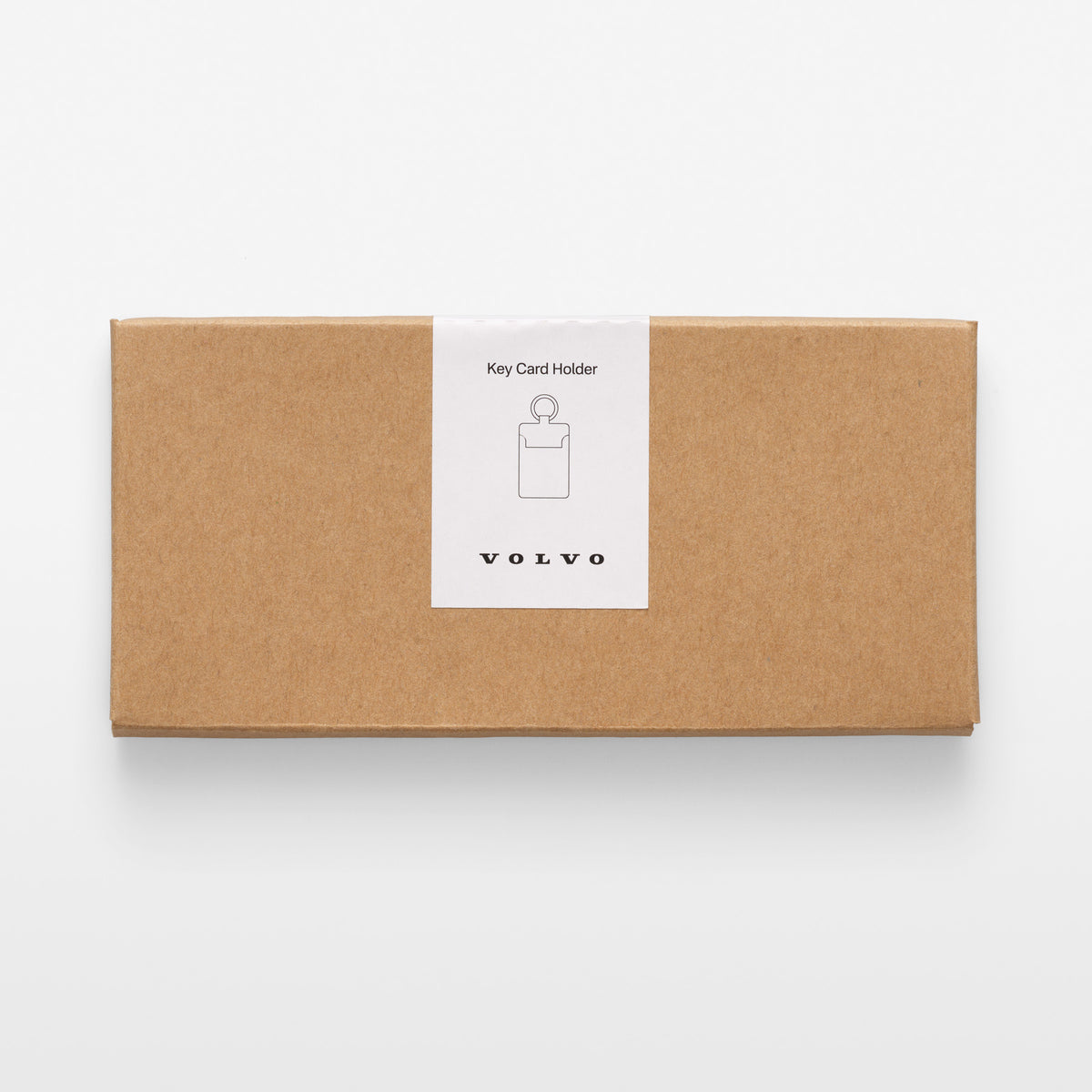 A rectangular brown kraft paper box with a white paper label on the front that reads 'Key Card Holder' with a simple key card icon and the brand name 'VOLVO' below it, photographed on a clean white background.