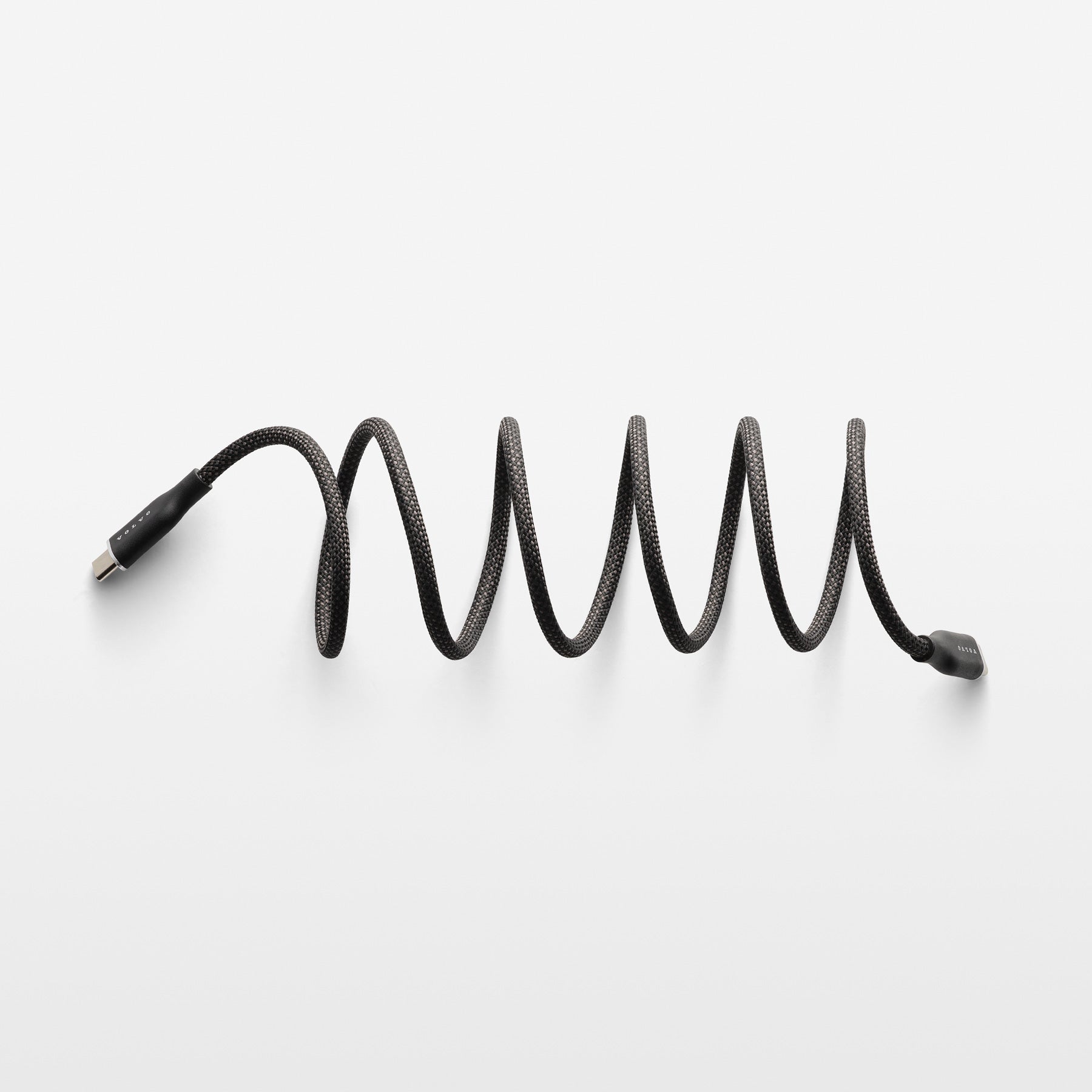 Coiled black cable on a white background