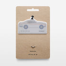 Keychain with a car silhouette design on a white background, on a beige card packaging with a white background