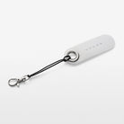 White reflective tag with black strap on a light gray background