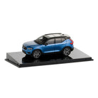Model of a blue SUV on a reflective platform with a white background