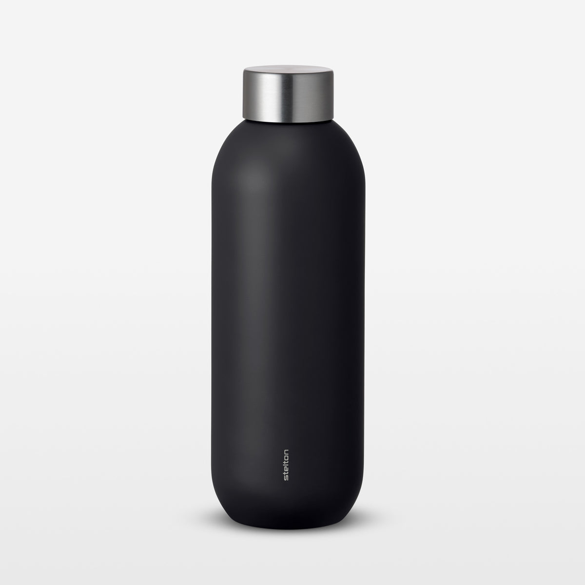 Black water bottle with silver cap on a light gray background