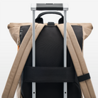 Volvo Backpack seen from back against a white background. The backpack is attached to a suitcase via a practical black strap. We see the adjustable straps and black handle on top.