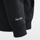 Black hoodie with 'For Life' text on a light gray background